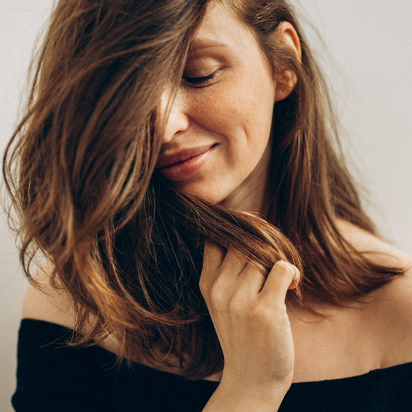 close up of woman smiling with beautiful skin and hair in face