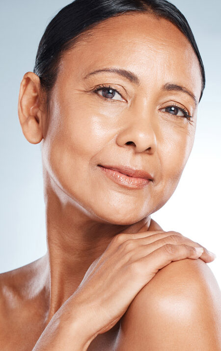 mature woman smiling with hand on her shoulder