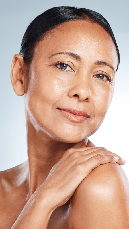 mature woman smiling with hand on her shoulder